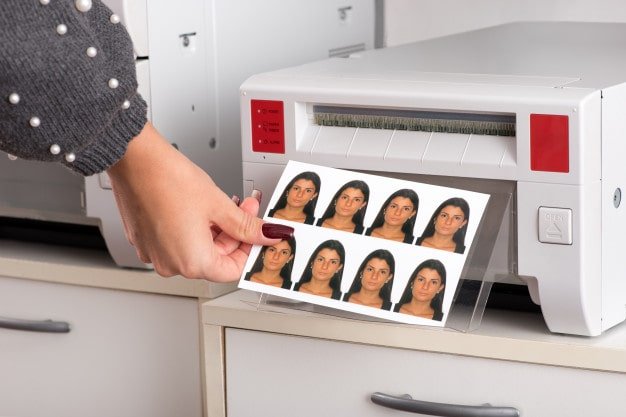 Passport photos coming out of a printer